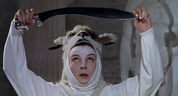 Movie still from “A Funny Thing Happened on the Way to the Forum” (1966), directed by Richard Lester – A person in a goat costume holding a knife; Close Up shot, Low angle