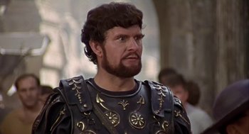 Movie still from “A Funny Thing Happened on the Way to the Forum” (1966), directed by Richard Lester – A person wearing a suit of armor; Close Up shot, Over the shoulder angle