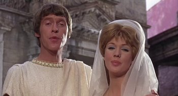 Movie still from “A Funny Thing Happened on the Way to the Forum” (1966), directed by Richard Lester – A man and a woman dressed in roman clothing; Close Up shot, Low angle