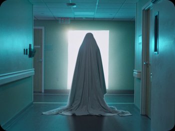 Movie still from “A Ghost Story” (2017), directed by David Lowery – A person that is standing in a room; Wide shot, Low angle