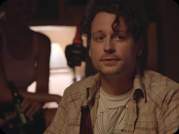 Movie still from “A Ghost Story” (2017), directed by David Lowery – A person holding a bottle of beer; Close Up shot, Over the shoulder angle