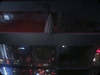 Movie still from “A Ghost Story” (2017), directed by David Lowery – A woman in a white dress standing on a balcony at night; Extreme Wide shot, Overhead angle