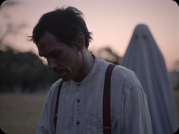 Movie still from “A Ghost Story” (2017), directed by David Lowery – A man wearing a white shirt and red suspenders; Medium shot, Over the shoulder angle