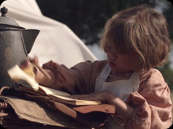 Movie still from “A Ghost Story” (2017), directed by David Lowery – A little girl sitting at a table looking at a piece of paper; Close Up shot, High angle