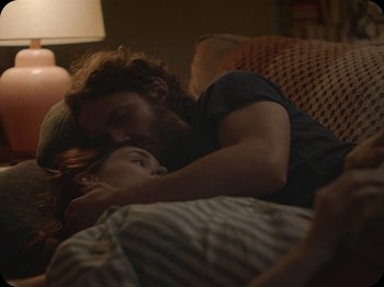 Movie still from “A Ghost Story” (2017), directed by David Lowery – A man and a woman laying on a couch; Medium shot, Over the shoulder angle