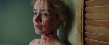 A woman with blood all over her face and neck