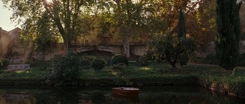 Movie still from “A Good Year” (2006), directed by Ridley Scott – A boat floating on top of a river near a bridge; Extreme Wide shot, High angle