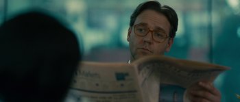Movie still from “A Good Year” (2006), directed by Ridley Scott – A man reading a newspaper while sitting in a chair; Close Up shot, Over the shoulder angle