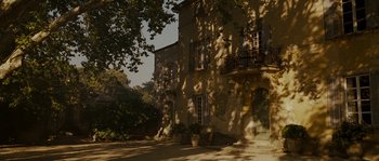 Movie still from “A Good Year” (2006), directed by Ridley Scott – A large stone building sitting next to a tree; Extreme Wide shot, High angle