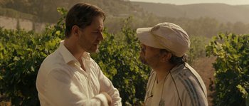 Movie still from “A Good Year” (2006), directed by Ridley Scott – Two men are standing outside talking to each other; Close Up shot, Over the shoulder angle