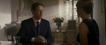 Movie still from “A Good Year” (2006), directed by Ridley Scott – A man sitting at a table in front of a window; Medium shot, Over the shoulder angle