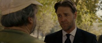 Movie still from “A Good Year” (2006), directed by Ridley Scott – A man wearing a suit and tie talking to another man wearing a suit and tie; Close Up shot, Over the shoulder angle