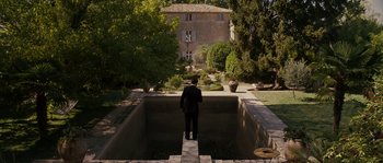 Movie still from “A Good Year” (2006), directed by Ridley Scott – A man standing in a pool of water in front of a building; Extreme Wide shot, High angle