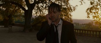 Movie still from “A Good Year” (2006), directed by Ridley Scott – A man wearing a suit and tie talking on a cell phone; Close Up shot, Low angle
