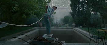 Movie still from “A Good Year” (2006), directed by Ridley Scott – A man standing on top of a box in a pool; Wide shot, Low angle
