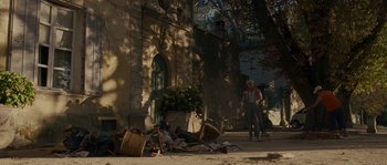 Movie still from “A Good Year” (2006), directed by Ridley Scott – An old man standing in front of an old building; Extreme Wide shot, Over the shoulder angle