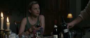 Movie still from “A Good Year” (2006), directed by Ridley Scott – A woman sitting at a table holding a glass of wine; Close Up shot, Over the shoulder angle