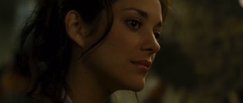 Movie still from “A Good Year” (2006), directed by Ridley Scott – A woman's face with a dark background; Close Up shot, Over the shoulder angle