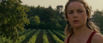 Movie still from “A Good Year” (2006), directed by Ridley Scott – A woman standing in front of a field of green plants; Close Up shot, Low angle