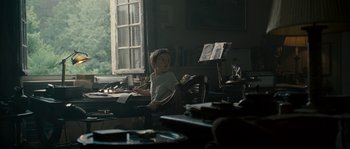 Movie still from “A Good Year” (2006), directed by Ridley Scott – A boy sitting at a table in a room; Medium shot, Over the shoulder angle