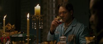Movie still from “A Good Year” (2006), directed by Ridley Scott – A man drinking a glass of wine at a dinner table; Medium shot, Over the shoulder angle
