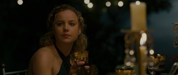 Movie still from “A Good Year” (2006), directed by Ridley Scott – A woman sitting at a table holding a glass of wine; Close Up shot, Over the shoulder angle