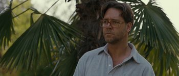Movie still from “A Good Year” (2006), directed by Ridley Scott – A person wearing glasses near a palm tree; Close Up shot, Over the shoulder angle