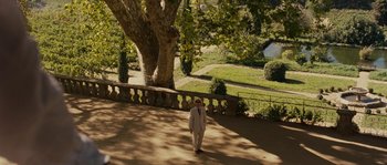 Movie still from “A Good Year” (2006), directed by Ridley Scott – A man in a white suit walking in a park; Extreme Wide shot, High angle
