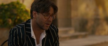 Movie still from “A Good Year” (2006), directed by Ridley Scott – A person wearing glasses and a jacket; Close Up shot, Over the shoulder angle