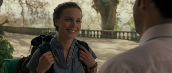 Movie still from “A Good Year” (2006), directed by Ridley Scott – A woman smiles while holding a backpack; Close Up shot, Over the shoulder angle