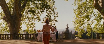 Movie still from “A Good Year” (2006), directed by Ridley Scott – Two women standing in front of an outdoor dining table; Extreme Wide shot, Over the shoulder angle