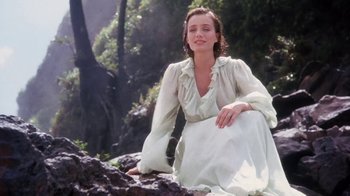 Movie still from “A Handful of Dust” (1988), directed by Charles Sturridge – A woman sitting on the ground in a white dress; Medium shot, Low angle