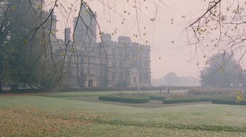 Movie still from “A Handful of Dust” (1988), directed by Charles Sturridge – A large building in the middle of a foggy park; Extreme Wide shot, High angle