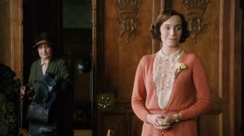 Movie still from “A Handful of Dust” (1988), directed by Charles Sturridge – A woman standing in front of a wooden door; Medium shot, Over the shoulder angle