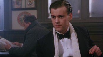 Movie still from “A Handful of Dust” (1988), directed by Charles Sturridge – A man in a suit and tie with a bow tie; Close Up shot, Low angle