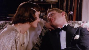 Movie still from “A Handful of Dust” (1988), directed by Charles Sturridge – A man and a woman sitting next to each other in a room; Medium shot, High angle