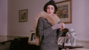 Movie still from “A Handful of Dust” (1988), directed by Charles Sturridge – A woman in a hat and a fur stole; Medium shot, Low angle