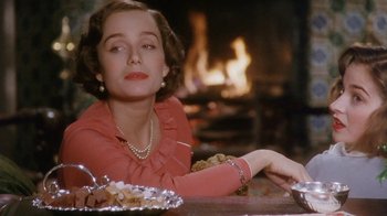 Movie still from “A Handful of Dust” (1988), directed by Charles Sturridge – A woman sitting in front of a fireplace; Close Up shot, Over the shoulder angle