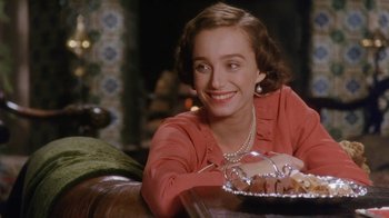 Movie still from “A Handful of Dust” (1988), directed by Charles Sturridge – A woman sitting at a table with a plate of food; Close Up shot, Over the shoulder angle