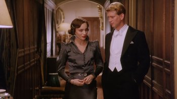 Movie still from “A Handful of Dust” (1988), directed by Charles Sturridge – A man and a woman standing next to each other in a room; Medium shot, Low angle