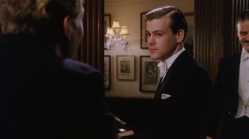 Movie still from “A Handful of Dust” (1988), directed by Charles Sturridge – A man in a suit and tie next to another man in a suit and tie; Close Up shot, Over the shoulder angle