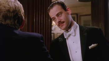 Movie still from “A Handful of Dust” (1988), directed by Charles Sturridge – A man with a mustache in a tuxedo; Close Up shot, Low angle