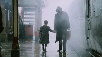 Movie still from “A Handful of Dust” (1988), directed by Charles Sturridge – A man and a boy walking on a train platform; Wide shot, Low angle