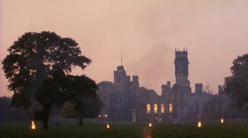 Movie still from “A Handful of Dust” (1988), directed by Charles Sturridge – A large building with a clock tower in the background; Extreme Wide shot, Low angle