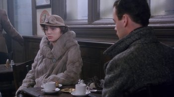 Movie still from “A Handful of Dust” (1988), directed by Charles Sturridge – A man and a woman are sitting at a table; Medium shot, Over the shoulder angle
