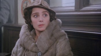 Movie still from “A Handful of Dust” (1988), directed by Charles Sturridge – A woman in a fur coat and a hat looking to her left; Close Up shot, Over the shoulder angle
