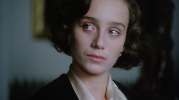 Movie still from “A Handful of Dust” (1988), directed by Charles Sturridge – A person wearing a suit and tie; Close Up shot, Over the shoulder angle