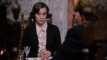 Movie still from “A Handful of Dust” (1988), directed by Charles Sturridge – A woman sitting in front of another woman at a dinner table; Medium shot, Over the shoulder angle