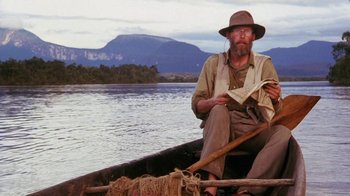 Movie still from “A Handful of Dust” (1988), directed by Charles Sturridge – A man sitting in a boat on a river; Wide shot, Low angle