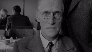 Movie still from “A Hard Day's Night” (1964), directed by Richard Lester – An older man wearing a suit and glasses; Close Up shot, Low angle